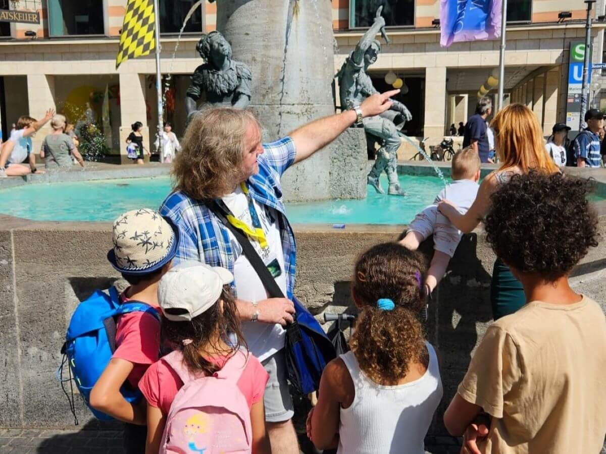 A Tour Guide Showing Marienplatz to a Group of Children